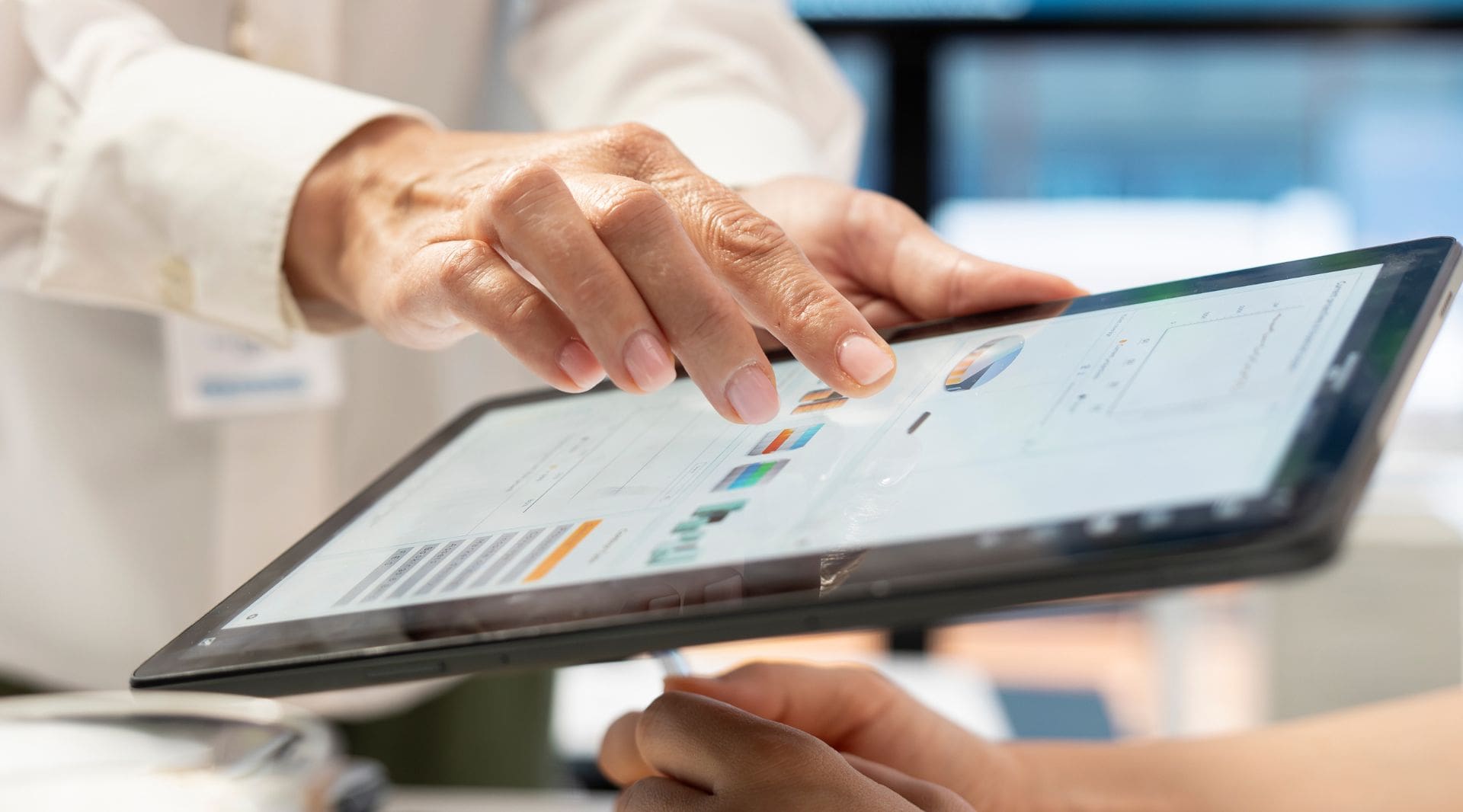 mãos utilizam tablet para analisar dados e indicadores